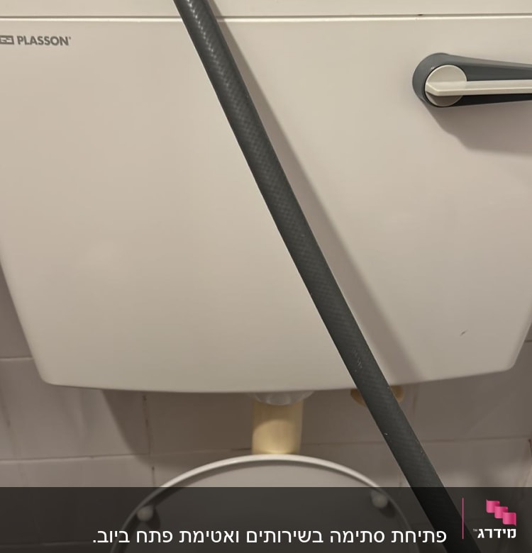 אסלה עם מיכל הדחה וצינור גומי שחור